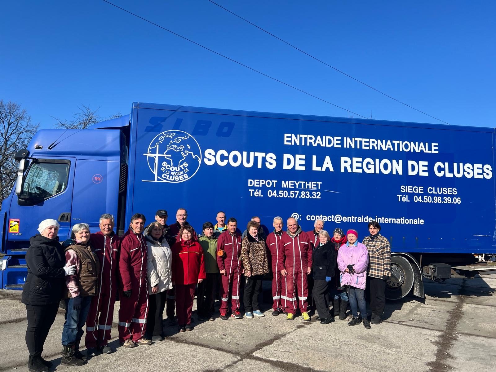 Bénévoles devant le camion de l'Entraide Internationale avant un départ de convoi